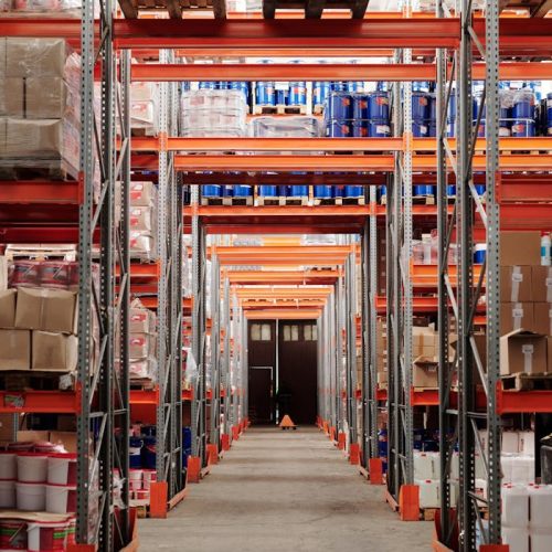 A modern warehouse interior showcasing organized shelves and pallets for efficient storage.